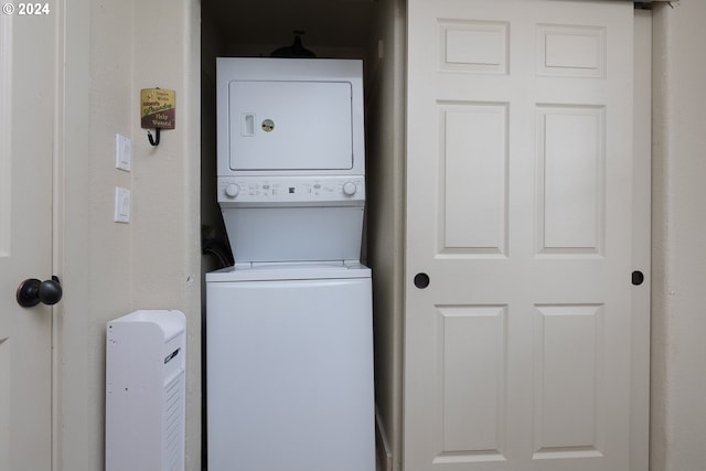 clothes washing area featuring stacked washer / dryer