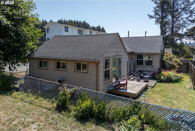 rear view of property featuring a wooden deck and a yard