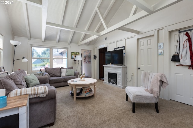 carpeted living room with a tile fireplace and lofted ceiling with beams