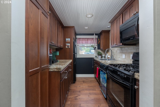 kitchen with sink, decorative backsplash, light stone counters, black appliances, and dark wood-type flooring