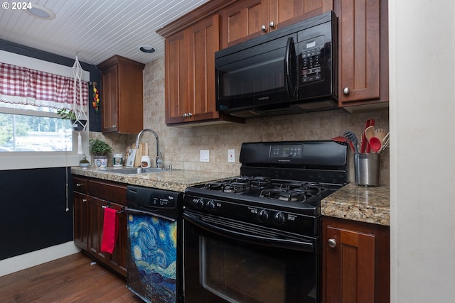 kitchen with dark wood-type flooring, sink, black appliances, and light stone countertops