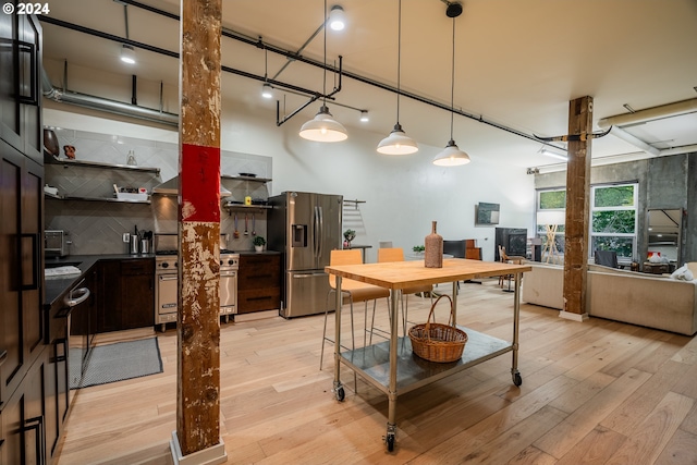 kitchen featuring light hardwood / wood-style flooring, stainless steel refrigerator with ice dispenser, decorative light fixtures, decorative backsplash, and dark brown cabinets