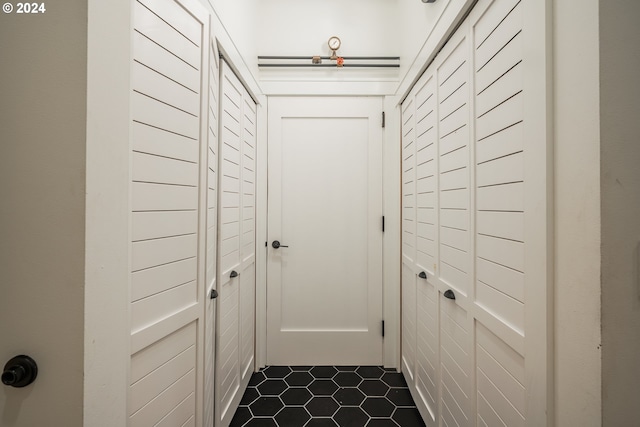 hall featuring dark tile patterned flooring