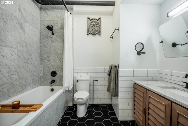 full bathroom with shower / tub combo, tile patterned floors, vanity, tile walls, and toilet