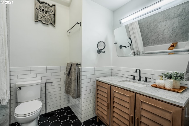 bathroom featuring tile patterned flooring, vanity, tile walls, and toilet