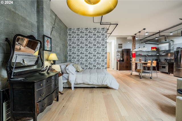 bedroom with stainless steel fridge with ice dispenser, sink, rail lighting, and wood-type flooring