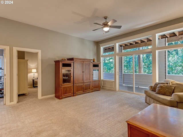 living room featuring ceiling fan, a healthy amount of sunlight, and light colored carpet