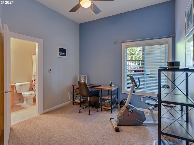 tiled office space featuring plenty of natural light, a ceiling fan, baseboards, and carpet