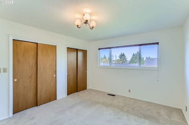 14940 SW 103rd Ave, Portland, OR 97224 - unfurnished bedroom with visible vents, carpet floors, a chandelier, multiple closets, and baseboards
