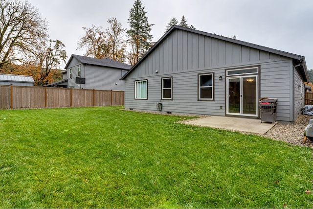 rear view of property with a lawn and a patio area