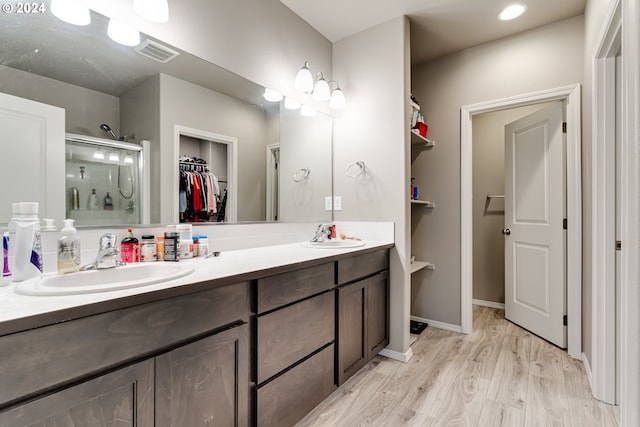 bathroom with vanity, hardwood / wood-style floors, and a shower with shower door