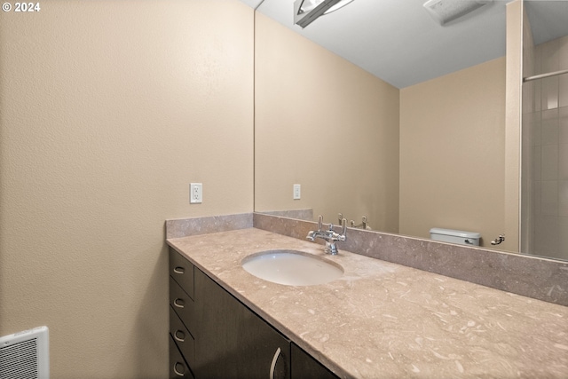 bathroom featuring a shower, vanity, and toilet