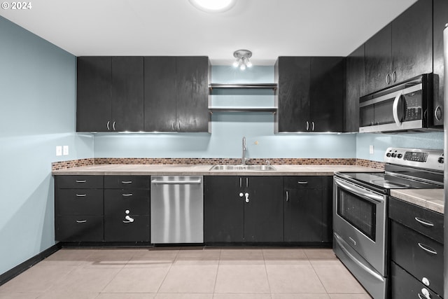 kitchen featuring light tile patterned flooring, sink, and stainless steel appliances