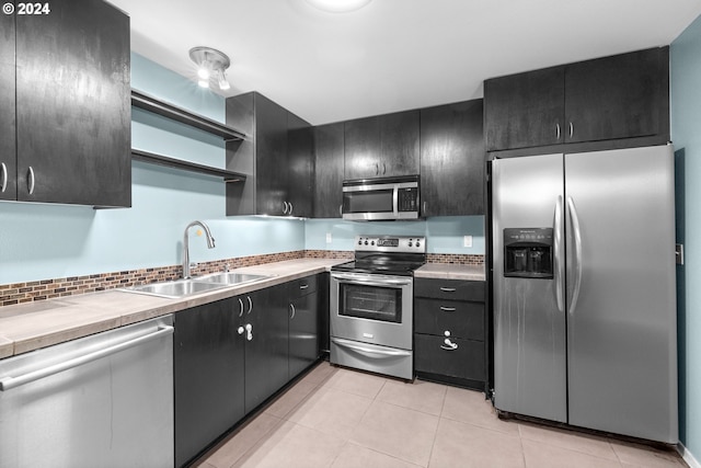 kitchen with sink, light tile patterned floors, and stainless steel appliances