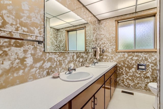 full bathroom with wallpapered walls, visible vents, and a sink