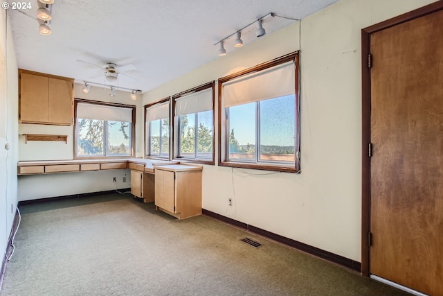 interior space featuring visible vents, carpet flooring, a ceiling fan, and baseboards