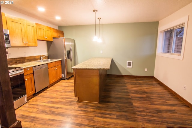 kitchen with a kitchen island, stainless steel appliances, hardwood / wood-style floors, and decorative light fixtures