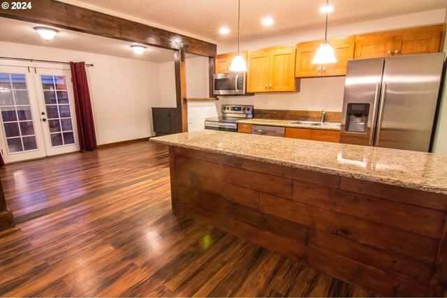 kitchen with dark wood-type flooring, pendant lighting, french doors, light stone countertops, and stainless steel appliances