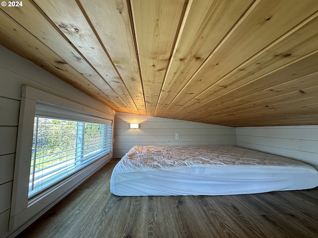 unfurnished bedroom with wood walls, hardwood / wood-style flooring, wooden ceiling, and lofted ceiling