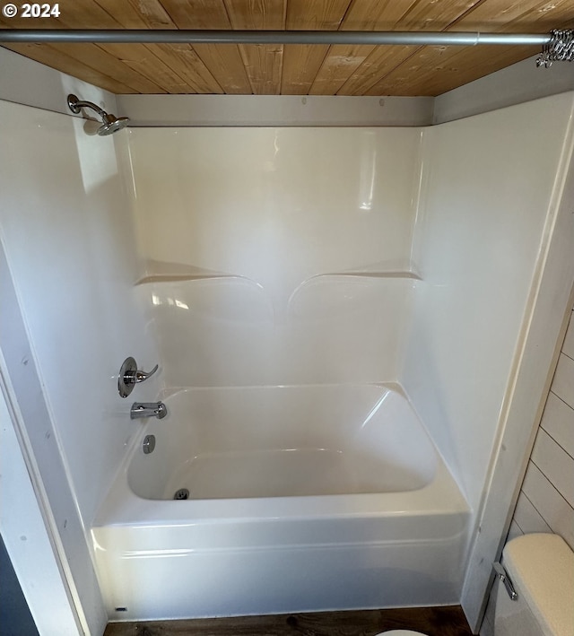 bathroom with wood ceiling, toilet, and shower / tub combination