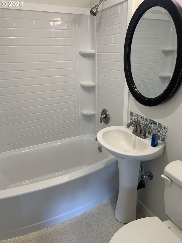 bathroom with tiled shower / bath combo and toilet