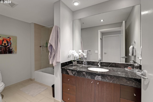 full bathroom featuring toilet, oversized vanity, tiled shower / bath combo, and tile flooring