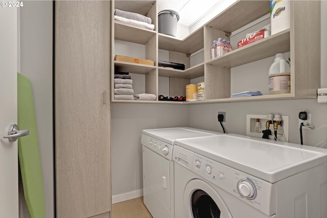 laundry room with hookup for an electric dryer, light tile flooring, and washer and dryer