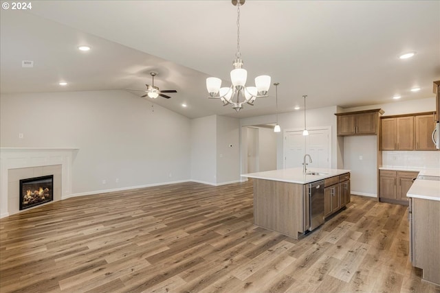 kitchen with a center island with sink, sink, vaulted ceiling, appliances with stainless steel finishes, and wood-type flooring