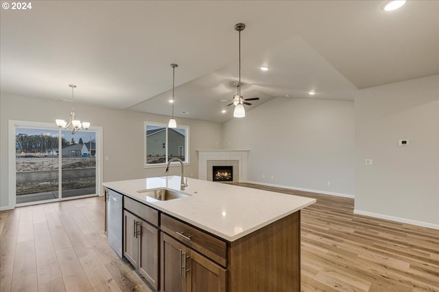 kitchen with sink, pendant lighting, ceiling fan with notable chandelier, and light hardwood / wood-style flooring