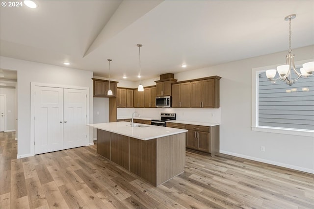 kitchen featuring an inviting chandelier, hanging light fixtures, sink, light wood-type flooring, and appliances with stainless steel finishes