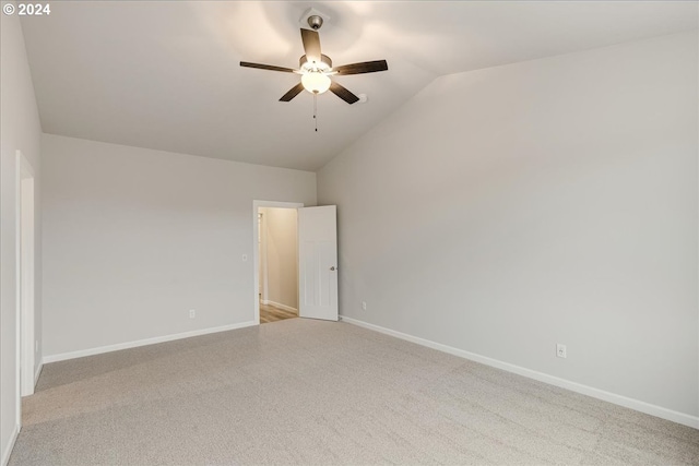 carpeted spare room with ceiling fan and vaulted ceiling