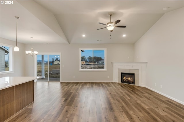 unfurnished living room featuring a tile fireplace, dark hardwood / wood-style flooring, and lofted ceiling