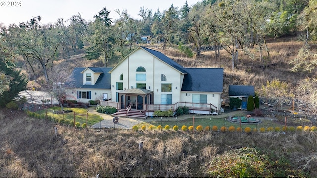 view of front of home with fence, a wooden deck, and a front lawn