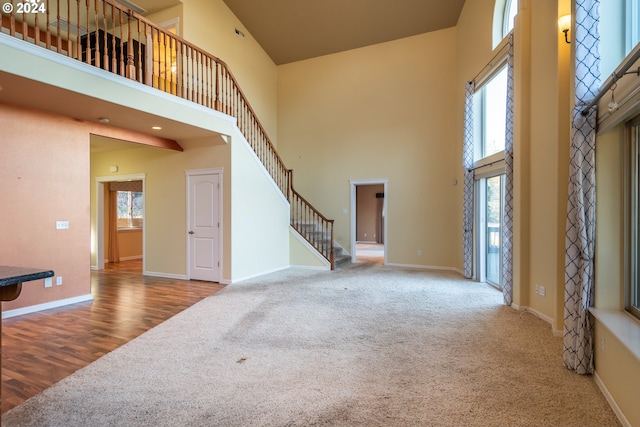 living room featuring plenty of natural light, hardwood / wood-style floors, and a high ceiling