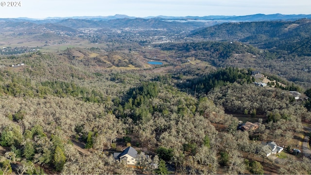 birds eye view of property with a wooded view and a mountain view