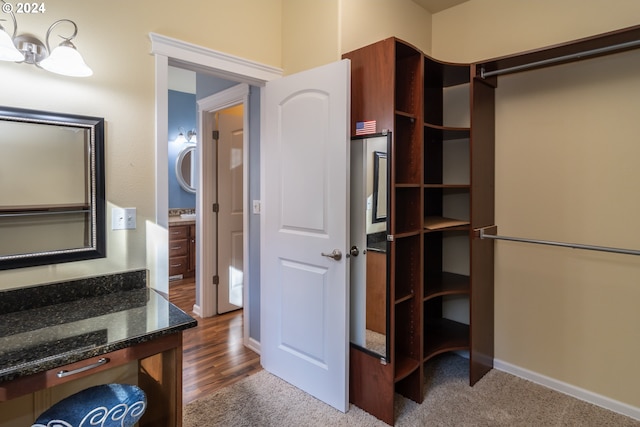 spacious closet with dark hardwood / wood-style flooring