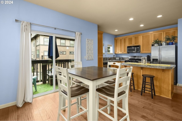 kitchen featuring stainless steel range, a kitchen island, a breakfast bar, and light wood-type flooring