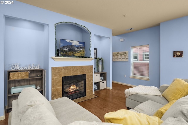 living room featuring dark wood-type flooring and a fireplace