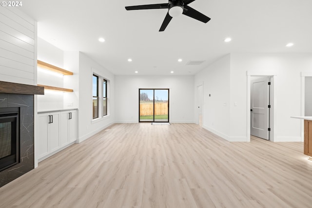 unfurnished living room featuring ceiling fan, light hardwood / wood-style flooring, and a fireplace