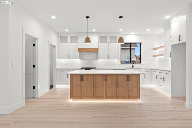 kitchen with a center island, white cabinetry, and light hardwood / wood-style flooring