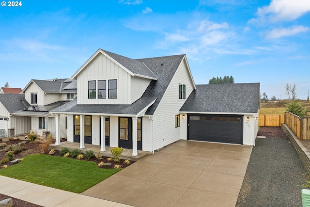 modern farmhouse style home with a garage, a porch, and a front lawn