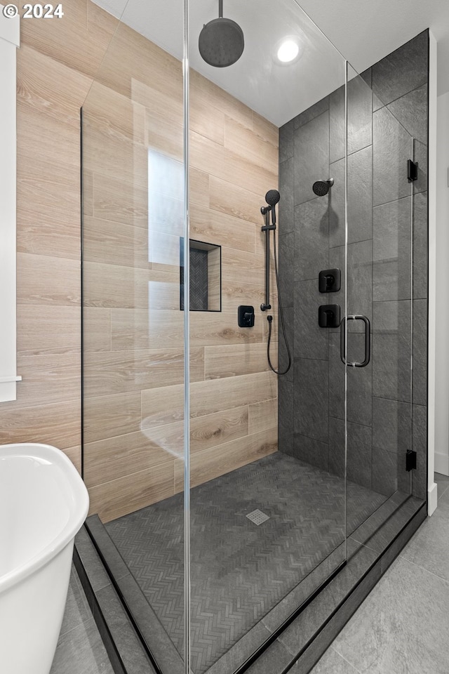 bathroom with shower with separate bathtub and tile patterned floors