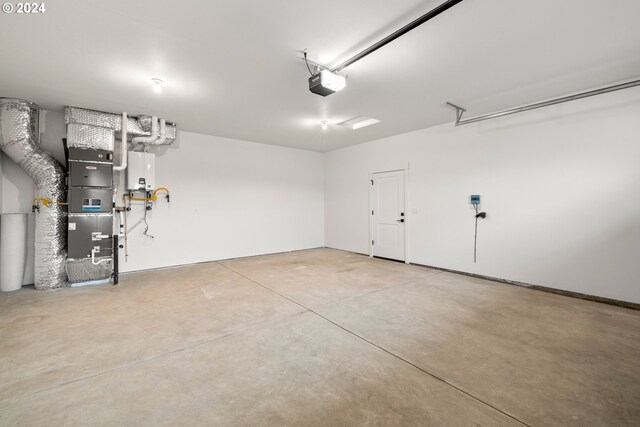 garage featuring a garage door opener, water heater, and heating unit