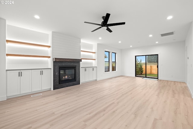 unfurnished living room featuring ceiling fan, light hardwood / wood-style flooring, and a fireplace