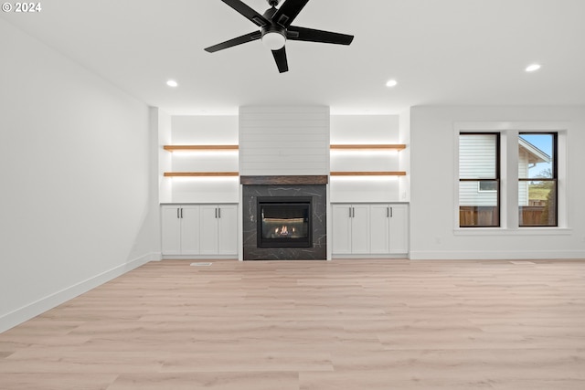 unfurnished living room featuring ceiling fan, light hardwood / wood-style flooring, and a high end fireplace