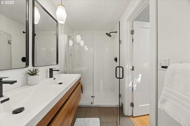 full bath featuring a shower stall, wood finished floors, and vanity