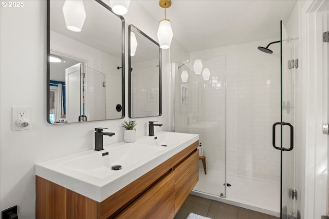 full bathroom with a sink, a shower stall, and double vanity