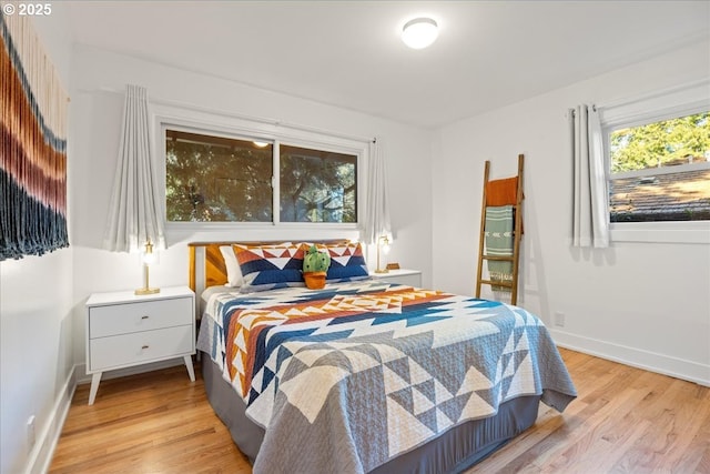 bedroom featuring light wood-style floors and baseboards