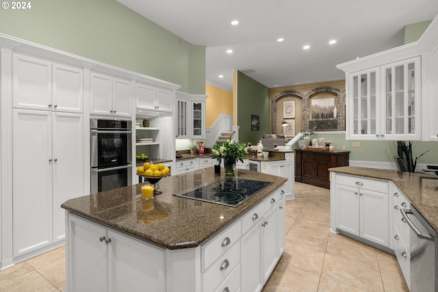 kitchen featuring dark stone countertops, white cabinetry, appliances with stainless steel finishes, and a center island