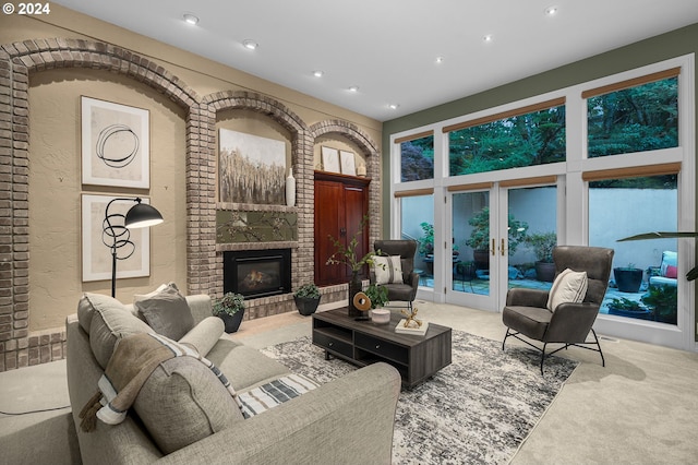 carpeted living room with a brick fireplace